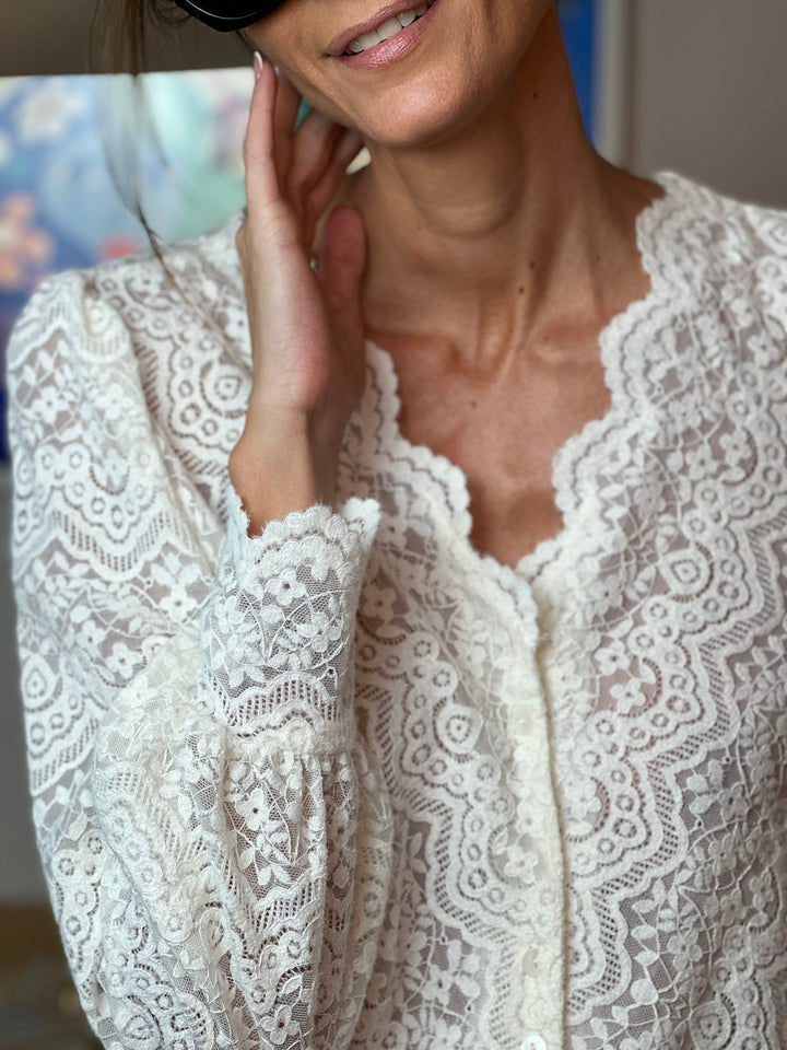 Close-up of the Hedda blouse neckline and decolleté with a soft smile